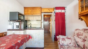 A compact room with a kitchenette, a dining area, and a sleeping area. - Cute studio apartment for 4 people, balcony and garage (Chamrousse)