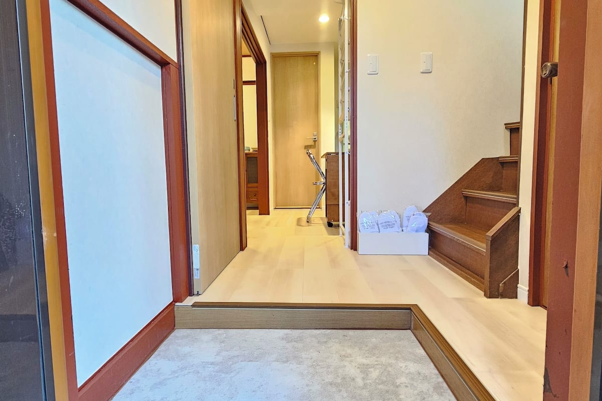 Un couloir avec un escalier en bois menant à l’étage supérieur.