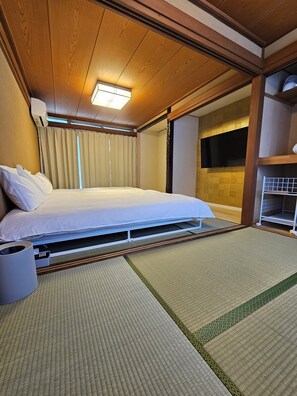 A hotel room with a bed, a ceiling fan, a window with curtains, and a built-in shelf. - HANAYADO SHINJUKU (Tokyo)
