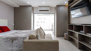 Ein modernes Hotelzimmer mit einem großen Bett, einem Flachbildfernseher und einem Balkon mit Blick auf die Stadt.