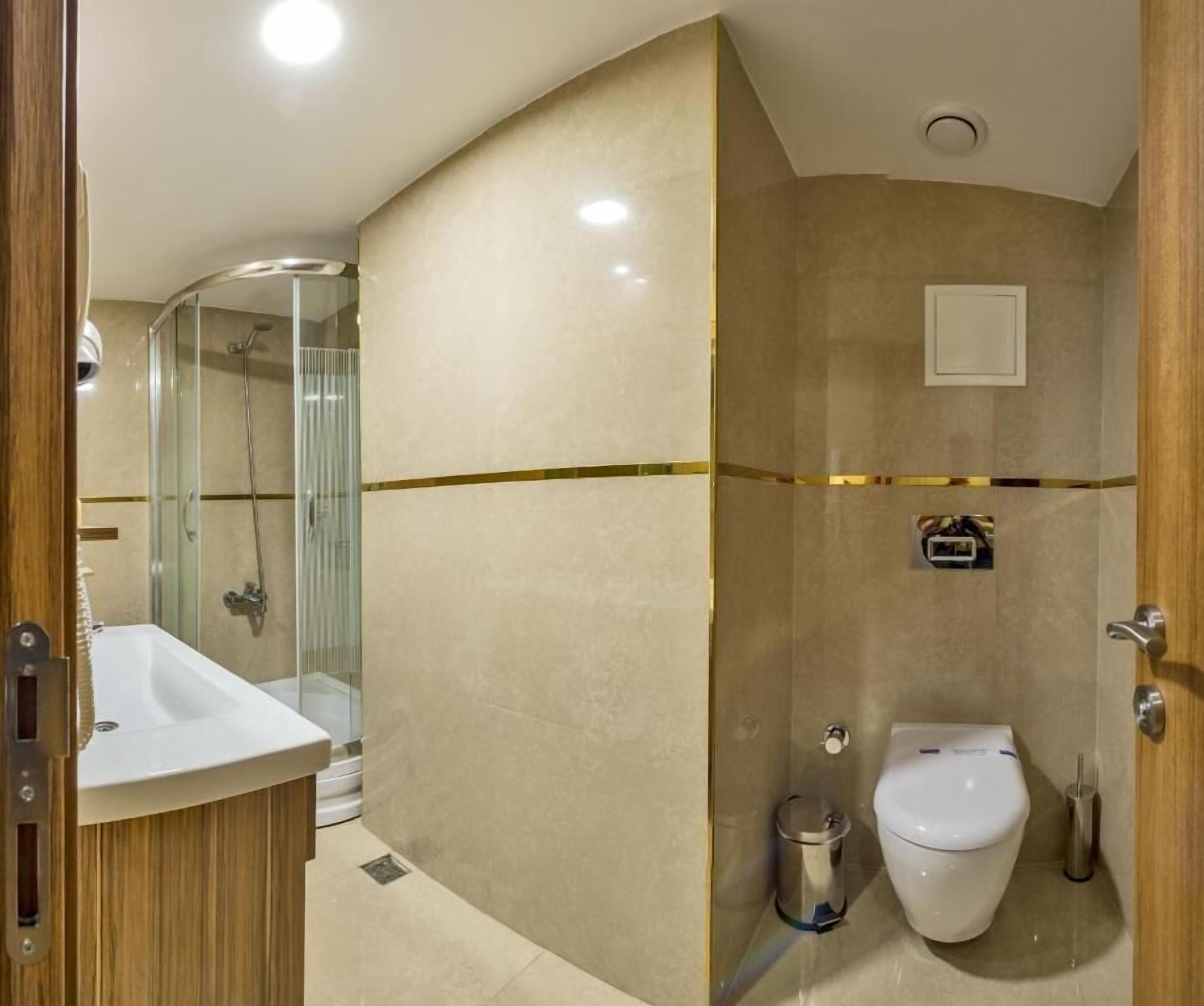 Un bany modern amb una cabina de dutxa de vidre, un lavabo i un vàter.