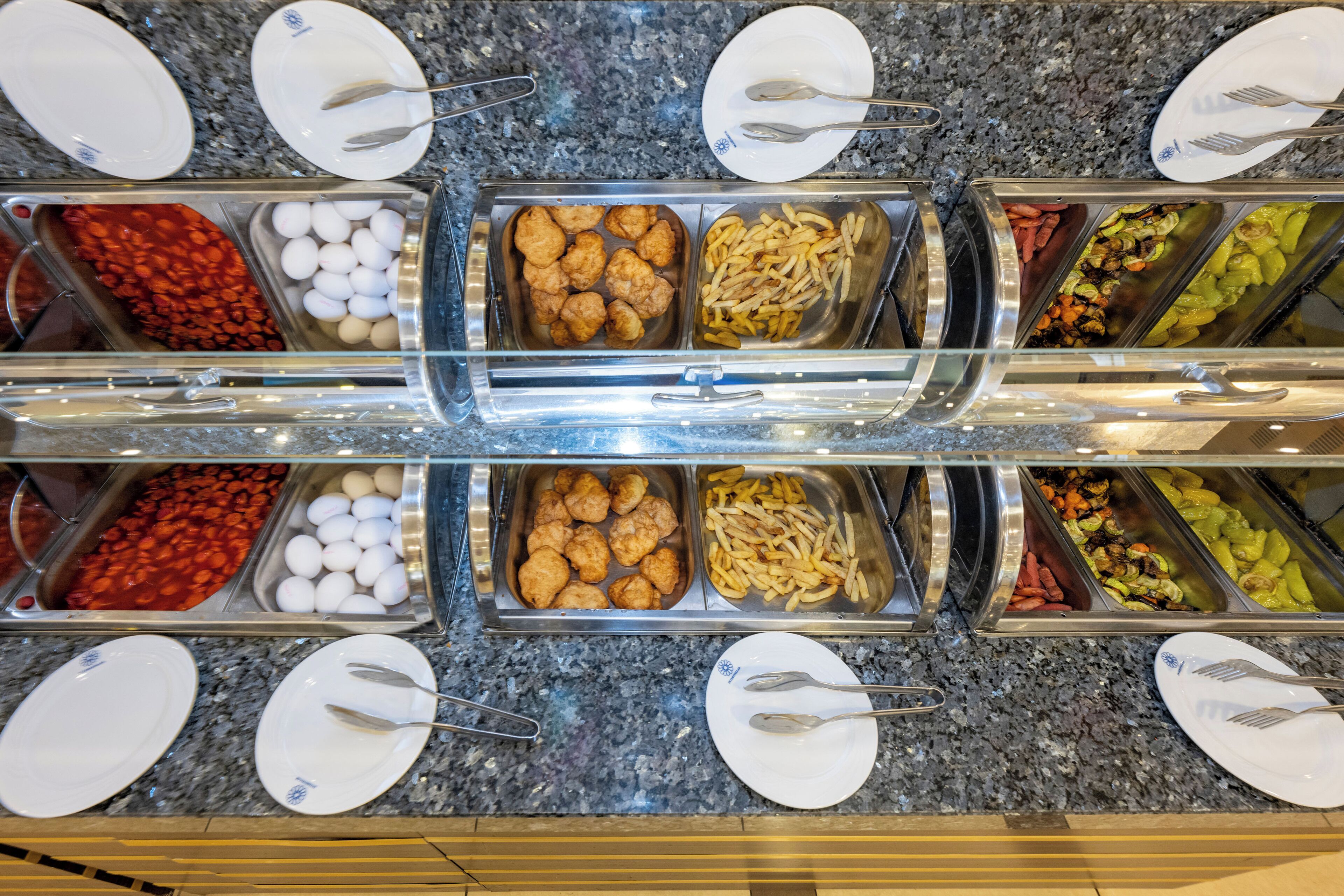 Buffet amb diverses opcions gastronòmiques, com ara ous, albóndigues i verdures.