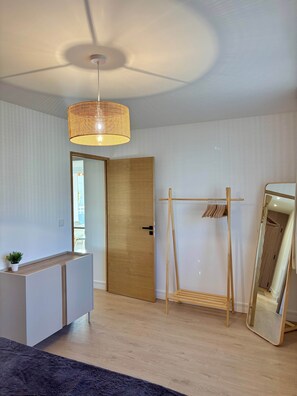 A modern room with a wooden door, a hanging light fixture, a mirror, and a wooden bench. - Apartment Xel-Lac, 4 pers, Annecy (Annecy)