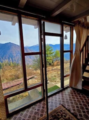A room with large windows, a patterned floor, and a view of mountains.