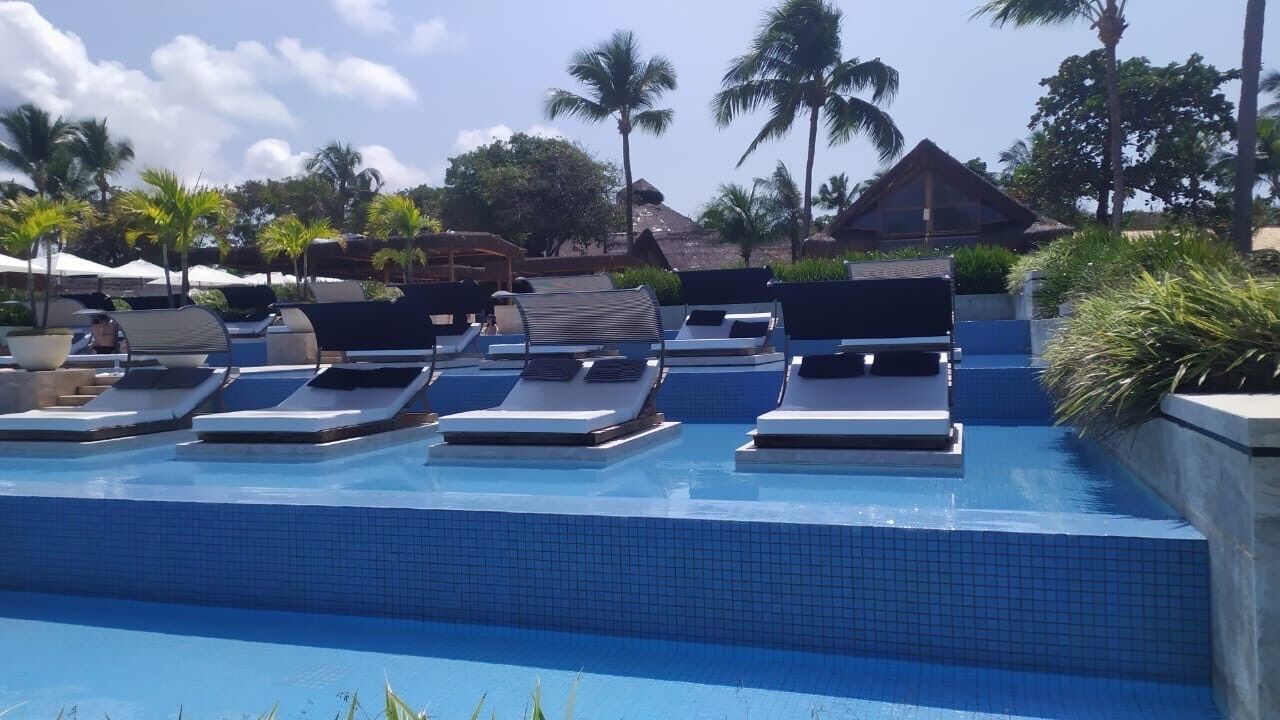 A pool area with lounge chairs and a tiled pool.