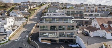 Un edificio moderno de varios pisos con un área de estacionamiento al frente.
