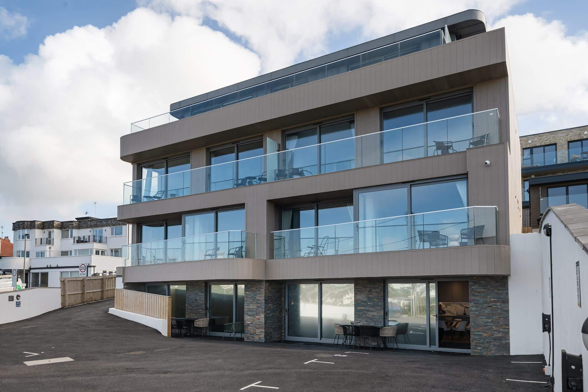 Un immeuble moderne à plusieurs étages, doté de grandes fenêtres et de balcons.