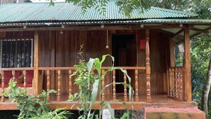 Ein Holzhaus mit Veranda, Tür und kleinem Garten.