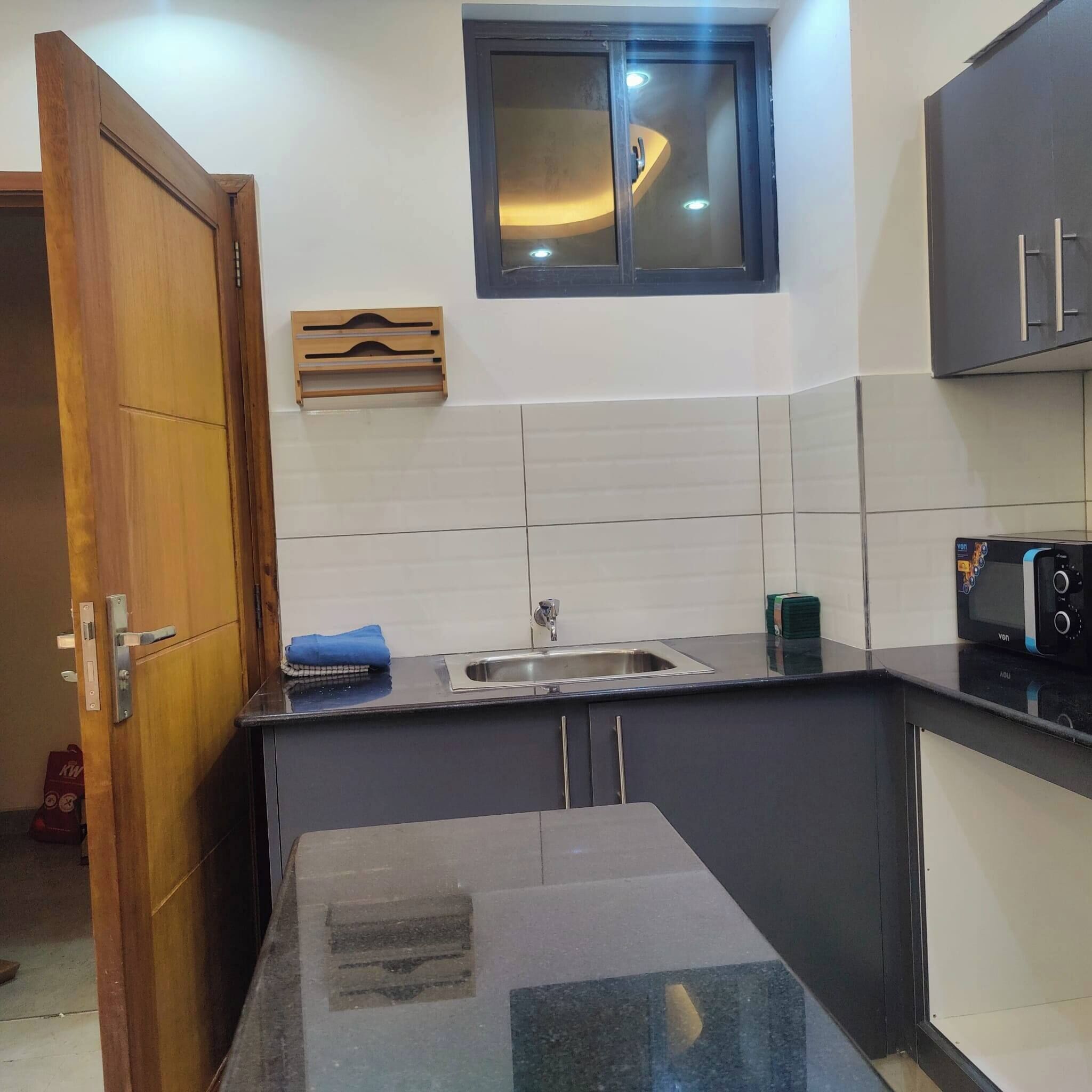 A kitchen with a sink, a microwave, and cabinets.