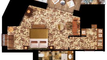 A hotel room with a wooden floor, a patterned carpet, a sofa, a small table, a chair, a bed, a bathroom with a marble floor, and a sink.