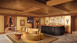 A spacious living room with a curved sofa, a small round table, and a decorative rug.