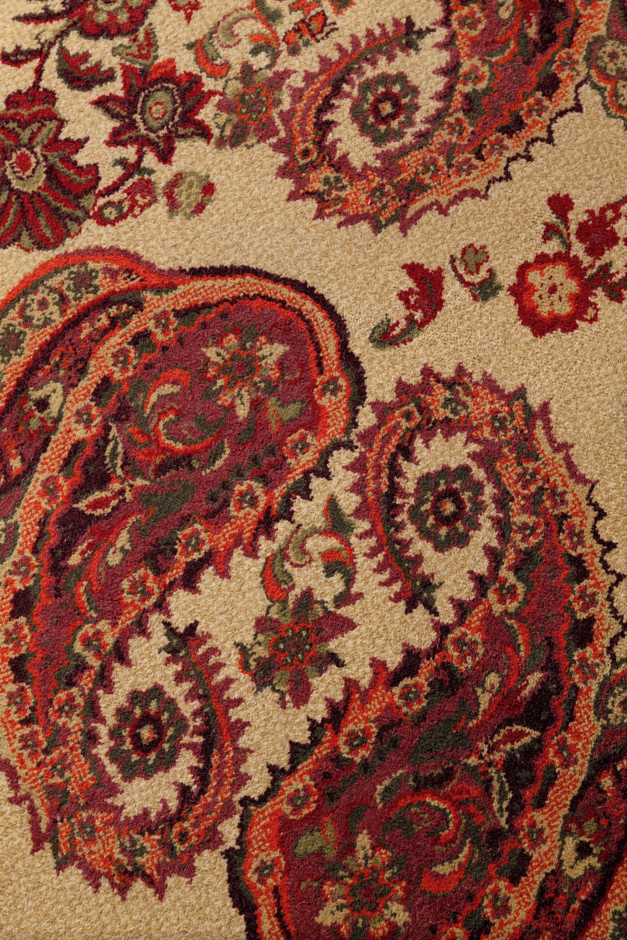 A close-up of a patterned carpet with floral and paisley designs.