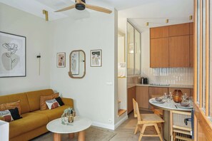 Ein modernes Wohnzimmer mit einer Couch, einem Couchtisch und einem Essbereich mit Stühlen und einem Tisch für zwei Personen.
