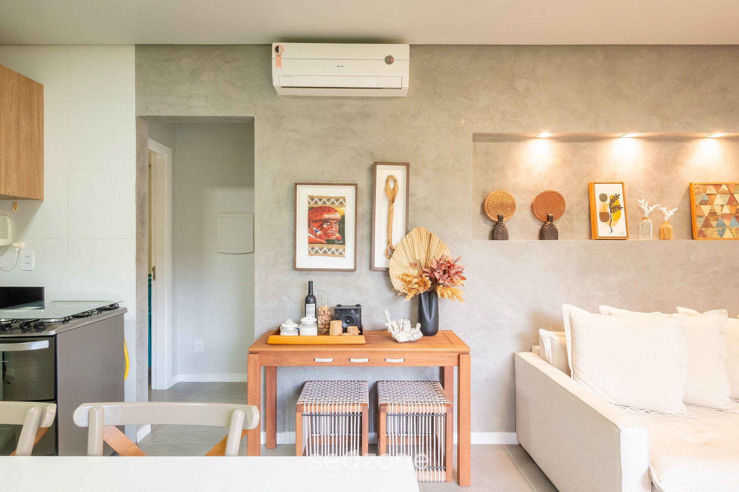 Una sala de estar moderna con un sofá, una mesa de centro de madera y un aire acondicionado instalado en la pared.