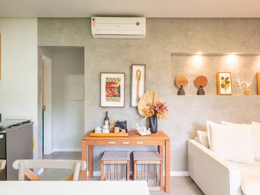 Una sala de estar moderna con un sofá, una mesa de centro de madera y un aire acondicionado instalado en la pared.