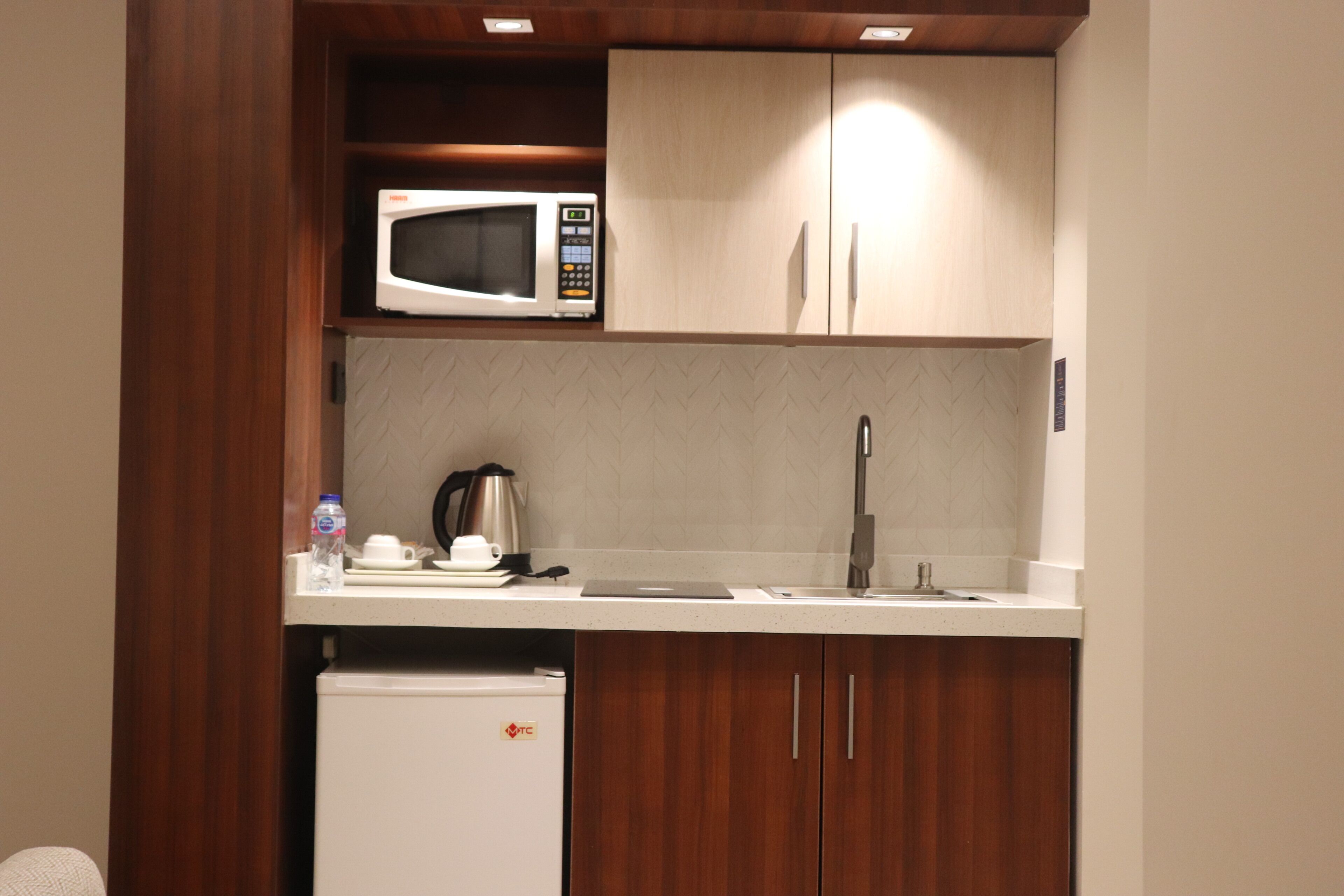 A compact kitchenette with a microwave, coffee maker, and a small refrigerator.
