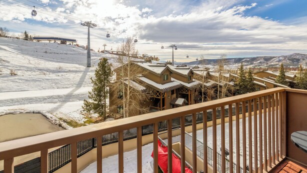 A snow-covered ski resort with a ski lift, chalets, and a view of the mountains. - Cute, cozy studio at Storm Meadows~Ski In, Walk Out! (Steamboat Springs)