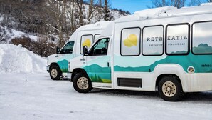 A white and green RV with "RETRIEATIA" branding parked on a snowy road. - Cute, cozy studio at Storm Meadows~Ski In, Walk Out! (Steamboat Springs)