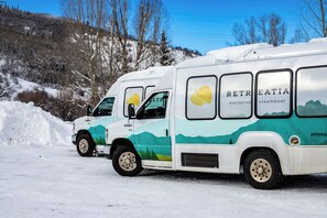 A white and green RV with 'RETRIEATIA' branding parked on a snowy road. - Cute, cozy studio at Storm Meadows~Ski In, Walk Out! (Steamboat Springs)