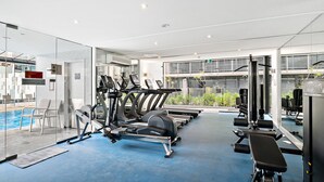 A modern gym with treadmills, elliptical machines, and weight equipment. - Stylish Southbank Apartment With On-site Parking (Melbourne)