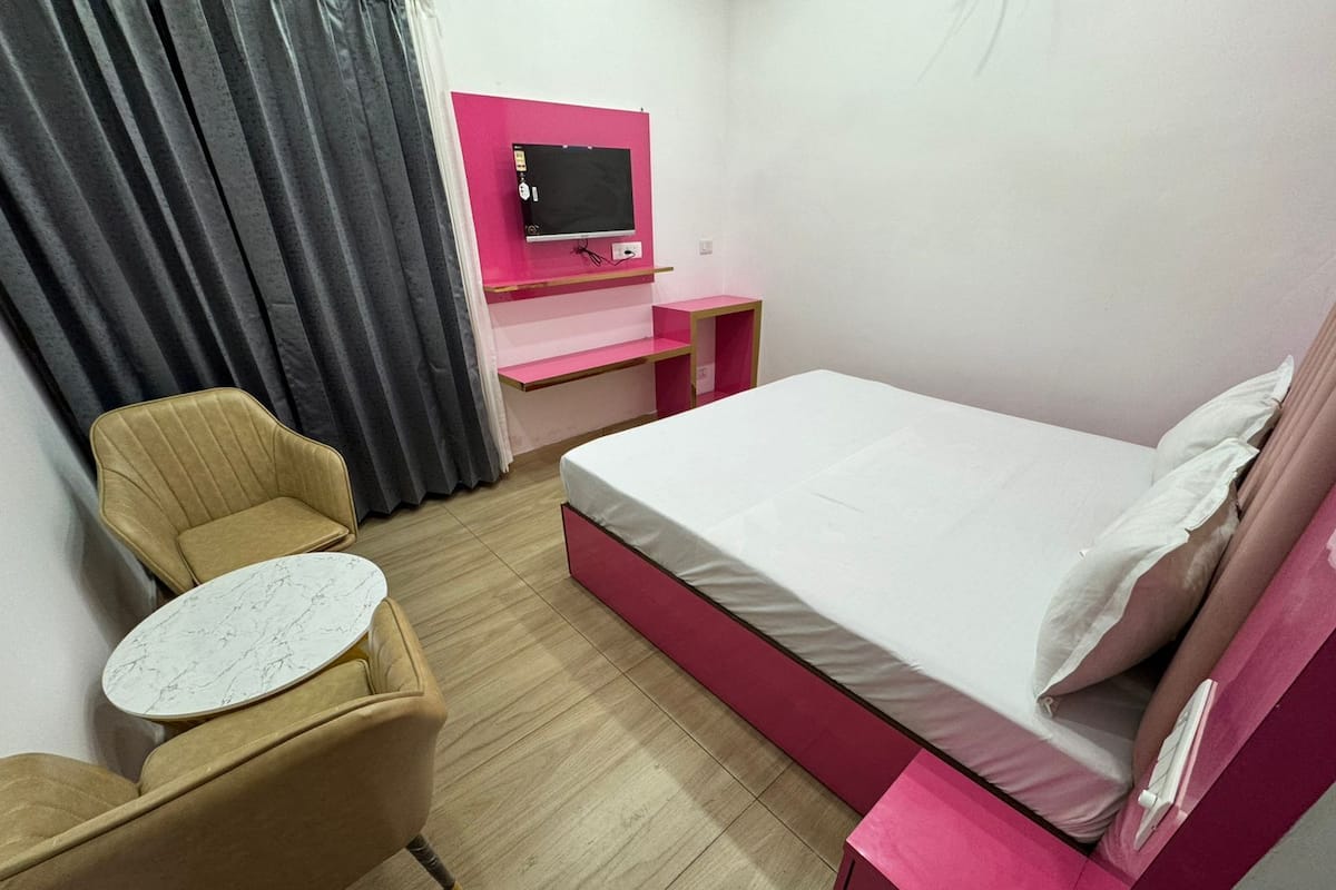 Een hotelkamer met een bed, een bureau, een stoel en een televisie.