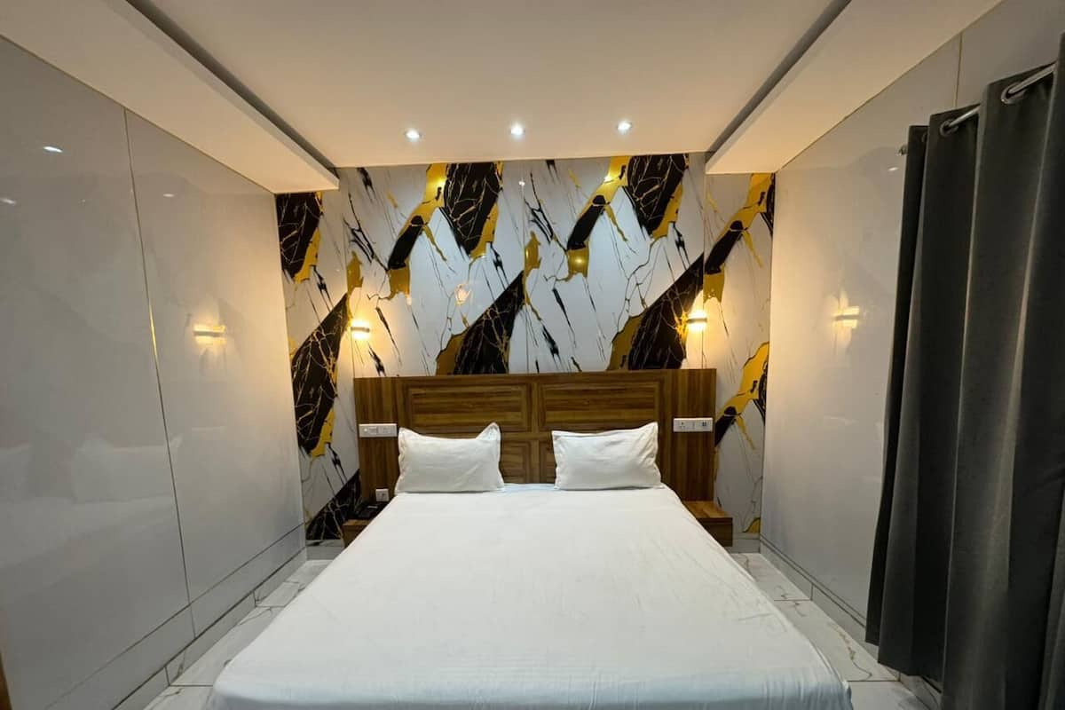 Een moderne slaapkamer met een groot bed, een houten hoofdbord en wanden met een marmerlook.