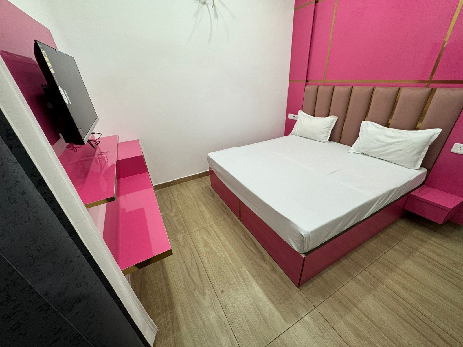 A modern bedroom with a bed, a TV, and a desk.