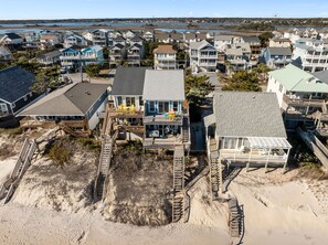 A coastal residential area with multiple houses, some with balconies and decks, and a sandy beach area with wooden walkways. - Beach Mountain #211 - 4 BR Oceanfront Surf City Townhome (Surf City)