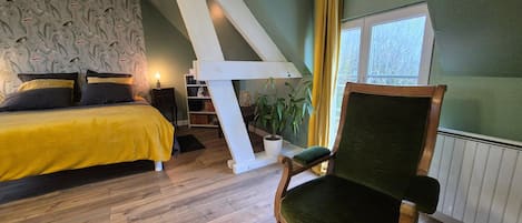 Ein Schlafzimmer mit Bett, Stuhl, Fenster und Treppe.