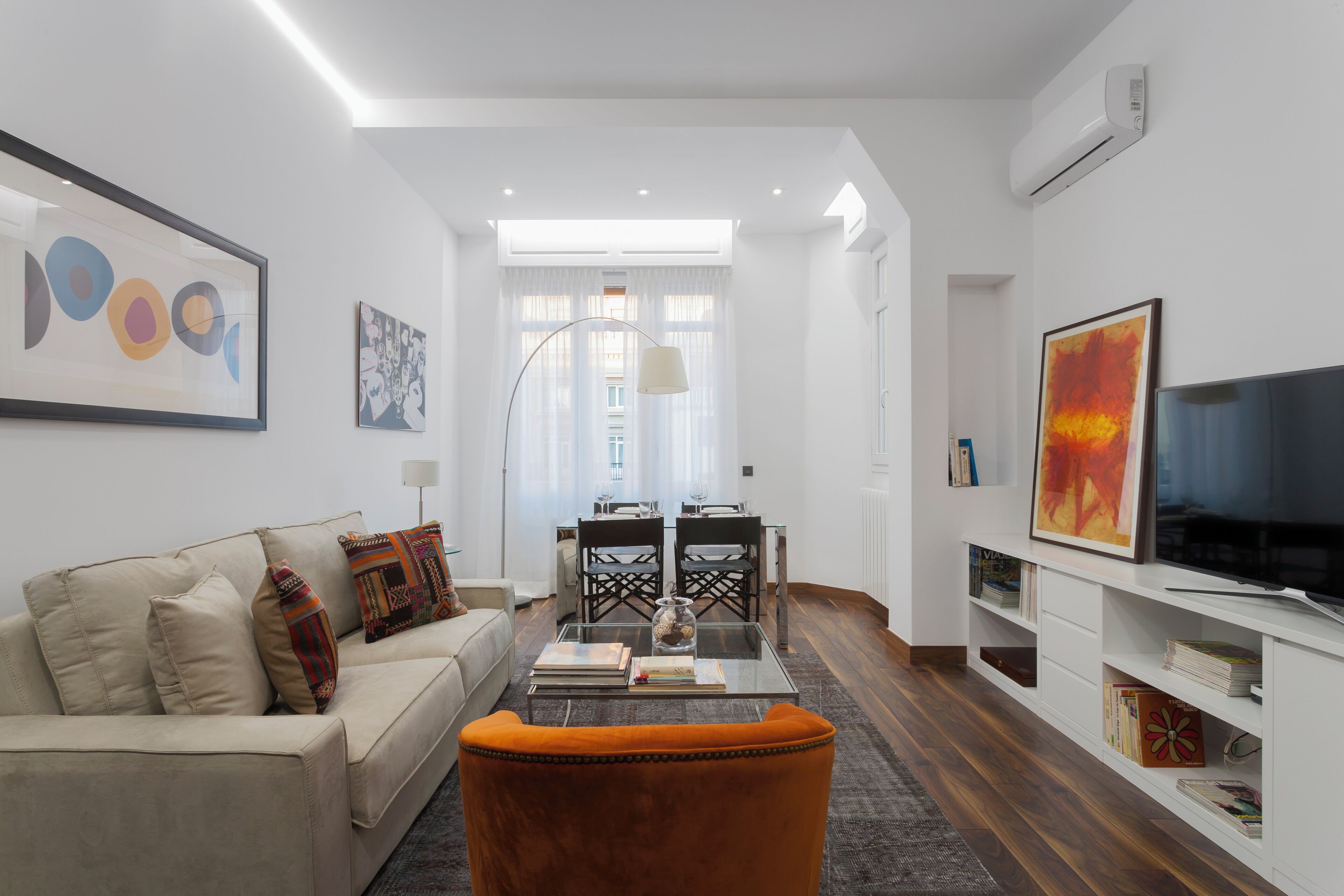A modern living room with a sofa, coffee table, and TV stand.