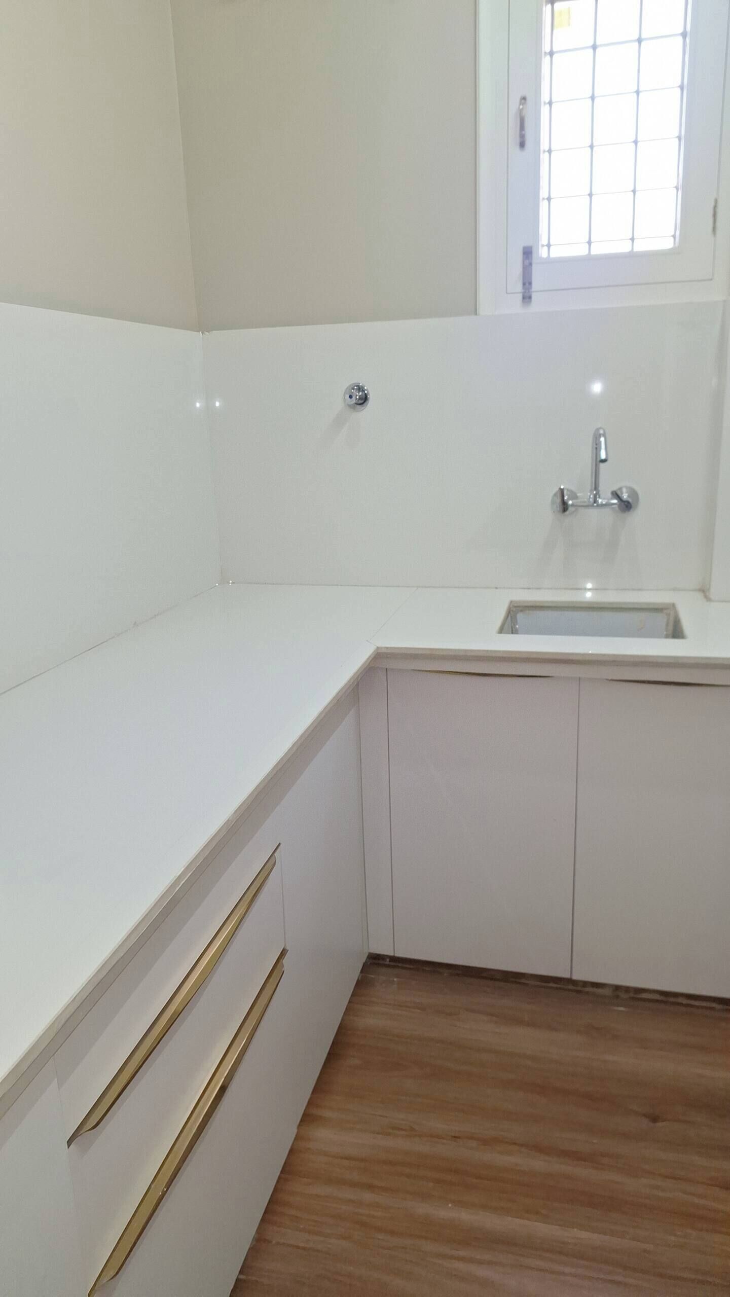 A kitchen with white cabinets, a wooden countertop, and a window above the sink.