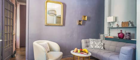 A modern living room with a grey sofa, a white armchair, and a round coffee table.