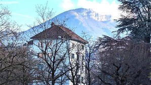 A building with a central tower, surrounded by trees and a mountain in the background. - Thank you Annecy - Near Lake (Annecy)