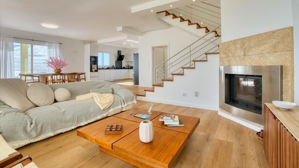 Un salon moderne avec un canapé, une table basse et une cheminée.