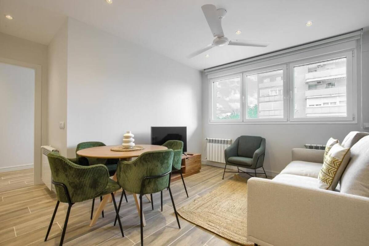 Ein modernes Wohnzimmer mit Essbereich, einer Couch, einem Fernseher und einem Kamin.