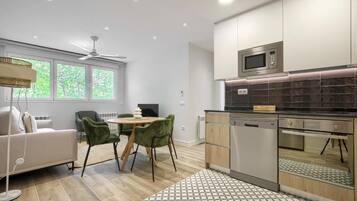 Una cocina moderna con comedor, que incluye un sofá, sillas y un ventilador de techo.