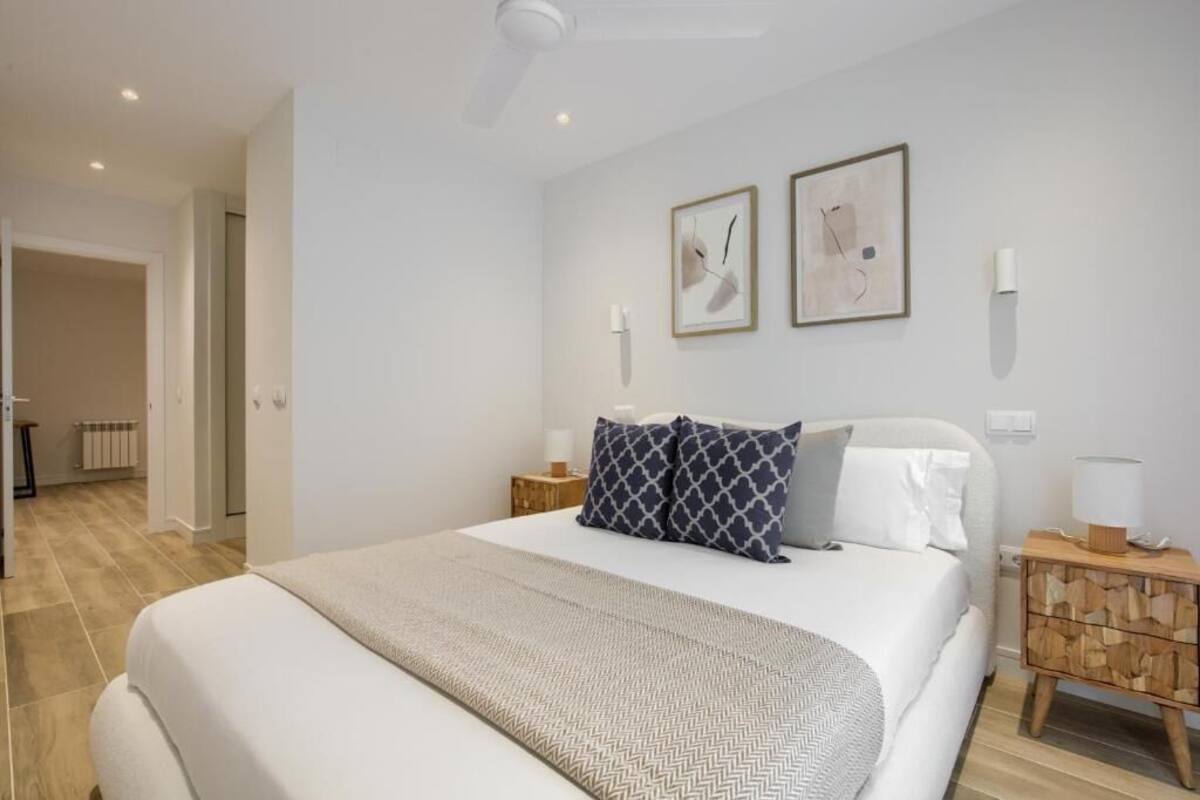 Ein modernes Schlafzimmer mit einem großen Bett, zwei Nachttischen und zwei Wandleuchten.