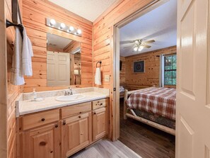 A wooden cabin bathroom with a sink, mirror, and towel rack. - Pet-Friendly  Mountain Cabin | Hot Tub & Fire Pit (Sautee Nacoochee)