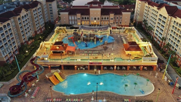 Ein Hotel mit großem Pool, Wasserrutschen und einer zentralen Fontäne.