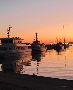 Ein Hafen im Abendrot mit mehreren vor Anker liegenden Booten.