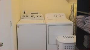 A laundry area with two white washing machines and a white laundry basket. - #34 Cozy in-law Port Richey Is an Entire Place (Port Richey)