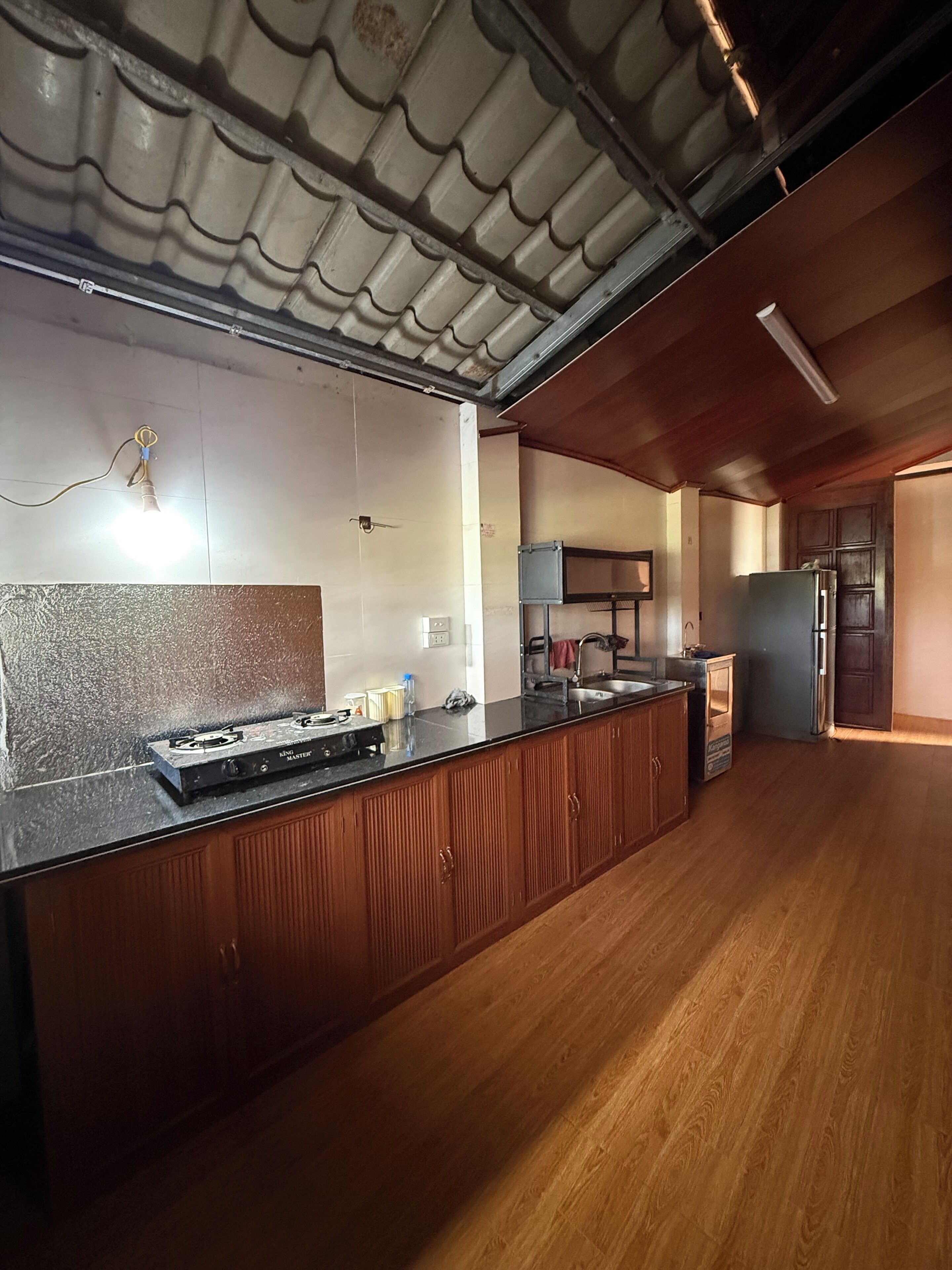 Eine Küche mit einer Holz Arbeitsplatte, einem Gasherd und einem Kühlschrank.