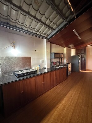 Une cuisine avec un plan de travail en bois, une cuisinière à gaz et un réfrigérateur.