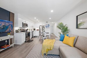 A modern apartment with a kitchen, dining area, and living room. - Coastal King Bed Villa, Steps from Beach, Parking! (San Diego)