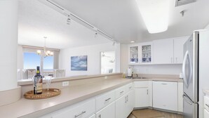 A modern kitchen with white cabinets, a stainless steel refrigerator, and a wooden countertop. - New listing! 3-bedroom. Ocean-Front, Corner Unit with Panoramic Views (Ormond Beach)