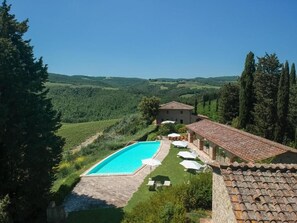 A villa with a swimming pool, outdoor seating, and vineyard views. - Santo Pietro Resort (San Gimignano)