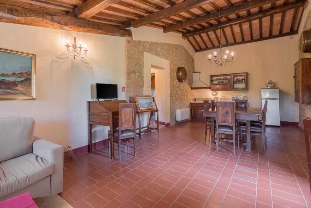 A spacious living area with a fireplace, wooden furniture, and a stone wall.