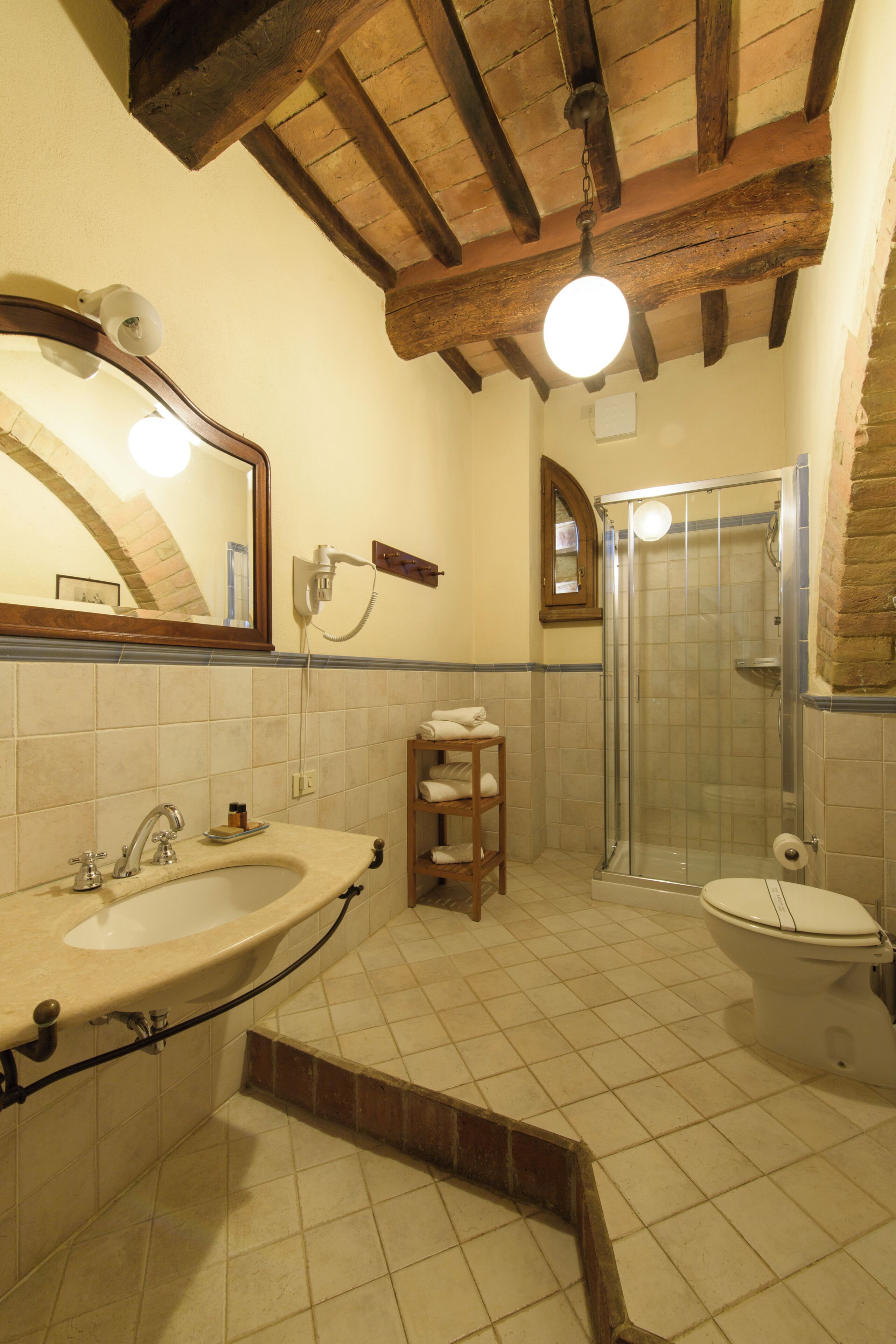 A bathroom with a sink, mirror, shower, and toilet.