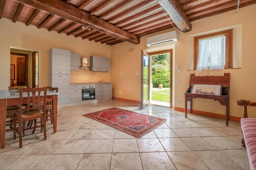 Une cuisine spacieuse avec un coin repas, un tapis rouge et un plafond en bois.