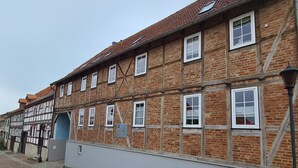 Un edificio tradicional con entramado de madera y muchos ventanales, y fachada de ladrillo.